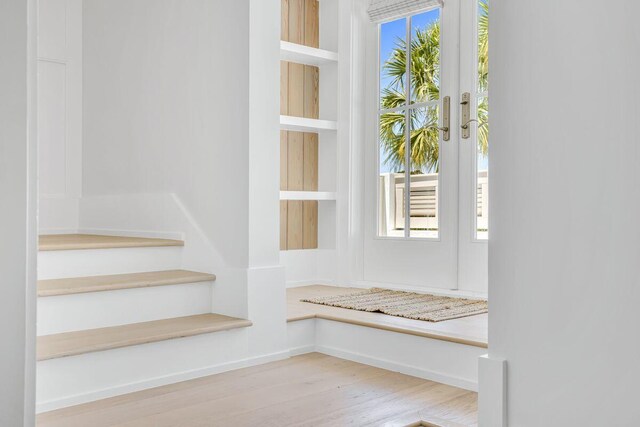 mudroom with wood finished floors, plenty of natural light, and baseboards