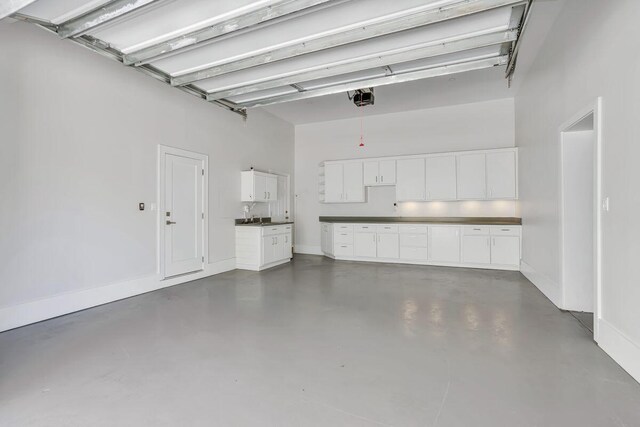 garage featuring a garage door opener and baseboards