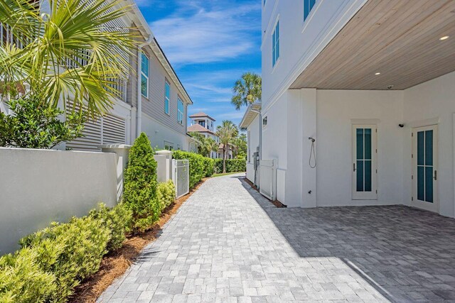 view of home's exterior with stucco siding, fence, and a patio area
