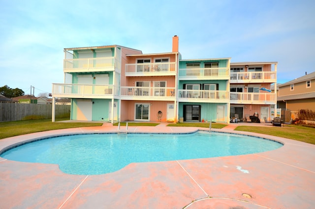 view of pool with a fenced in pool, fence, and a lawn