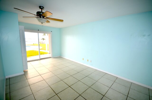 empty room featuring light tile patterned floors, baseboards, and a ceiling fan