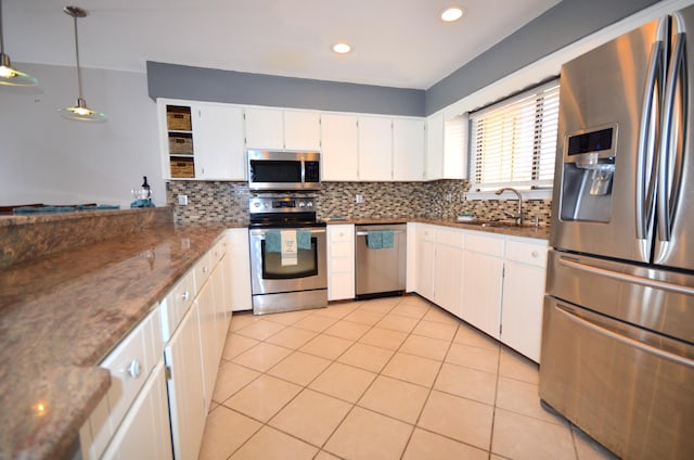 kitchen featuring decorative backsplash, appliances with stainless steel finishes, white cabinetry, pendant lighting, and a sink