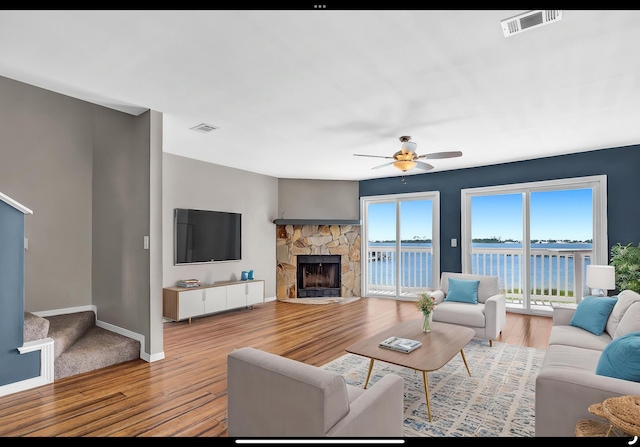 living area featuring ceiling fan, baseboards, wood finished floors, and visible vents