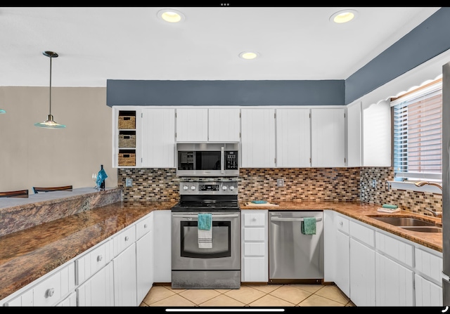 kitchen featuring white cabinets, stainless steel appliances, a sink, and backsplash