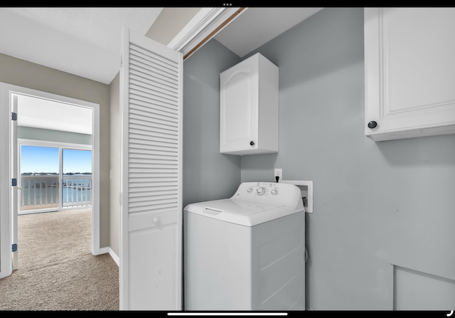 clothes washing area with baseboards, carpet, washer / clothes dryer, and cabinet space