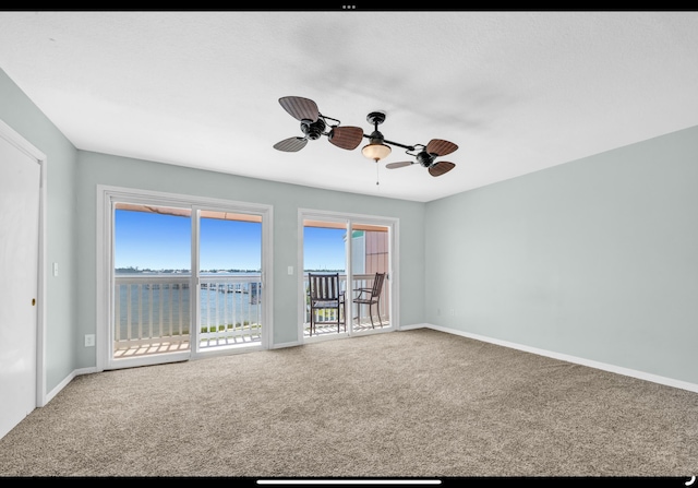 spare room featuring ceiling fan, baseboards, and carpet flooring