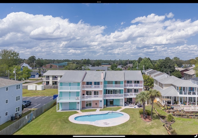 exterior space featuring a lawn, a community pool, and a residential view