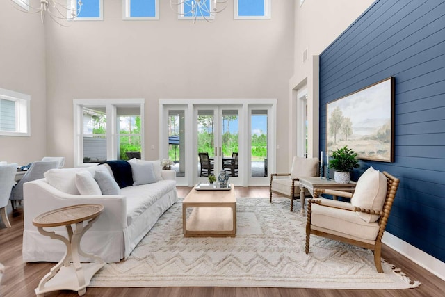 1760 Pathways Dr, Inlet Beach, FL 32461 - living room featuring a towering ceiling, wood finished floors, a chandelier, and wood walls