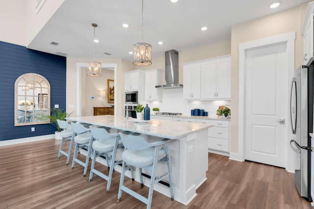 1760 Pathways Dr, Inlet Beach, FL 32461 - kitchen with wall chimney range hood, stainless steel appliances, a chandelier, an island with sink, and white cabinetry