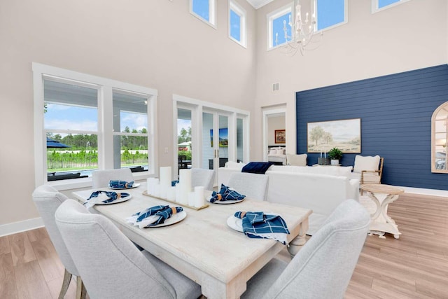 1760 Pathways Dr, Inlet Beach, FL 32461 - dining room featuring a chandelier, light wood-style flooring, baseboards, and a high ceiling