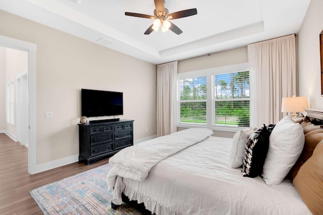 1760 Pathways Dr, Inlet Beach, FL 32461 - bedroom featuring a raised ceiling, baseboards, wood finished floors, and a ceiling fan