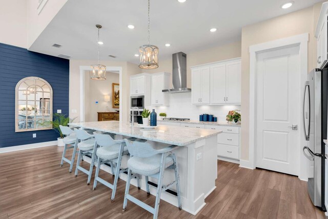 1760 Pathways Dr, Inlet Beach, FL 32461 - kitchen featuring wall chimney range hood, appliances with stainless steel finishes, a chandelier, an island with sink, and white cabinets