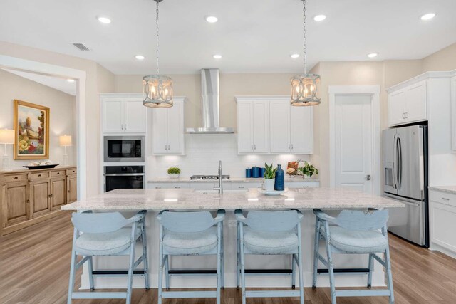 1760 Pathways Dr, Inlet Beach, FL 32461 - kitchen featuring stainless steel appliances, wall chimney range hood, a chandelier, decorative backsplash, and light wood-style floors