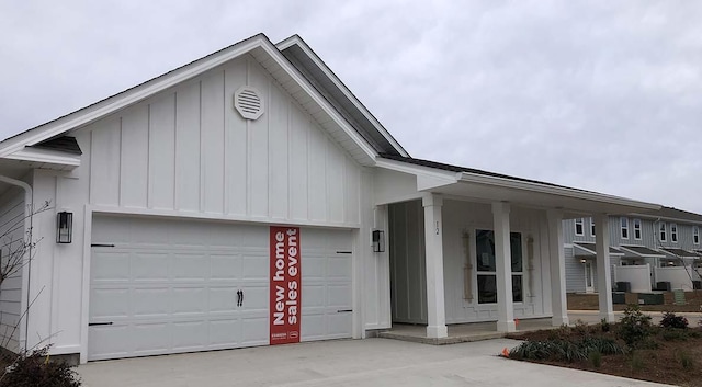 view of front of house with a garage, a porch, board and batten siding, and concrete driveway