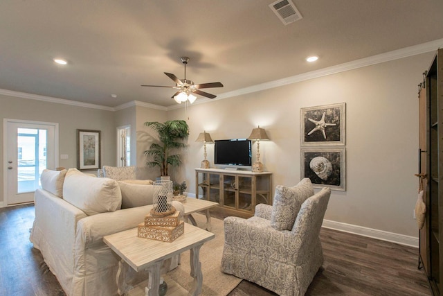 living room featuring ornamental molding, dark wood-style flooring, visible vents, and baseboards