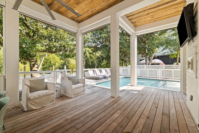 unfurnished sunroom with lofted ceiling, plenty of natural light, and wood ceiling