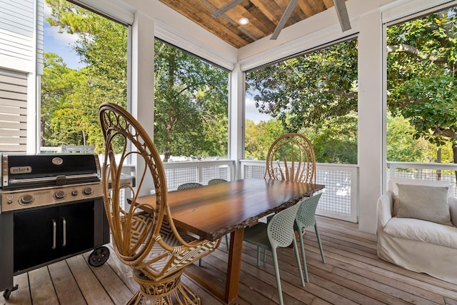 sunroom with a healthy amount of sunlight, wooden ceiling, and vaulted ceiling