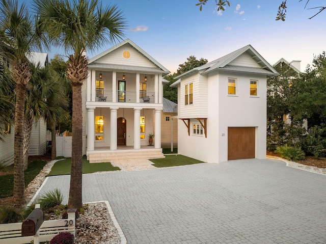 view of front facade featuring a balcony, decorative driveway, and stucco siding