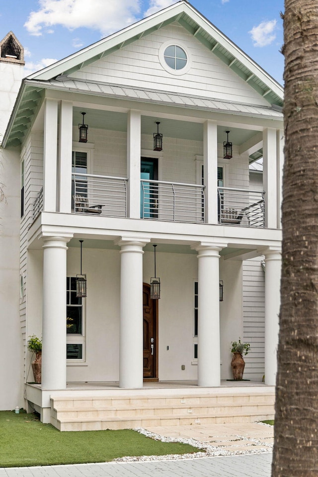 view of front of home featuring a balcony, a standing seam roof, metal roof, and a porch