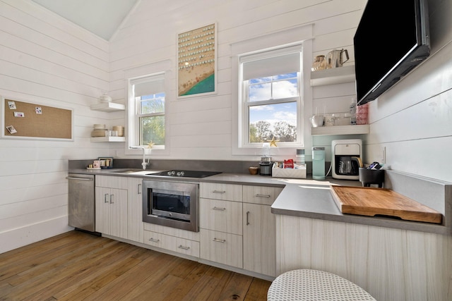 kitchen featuring light wood finished floors, open shelves, wall oven, vaulted ceiling, and dishwasher