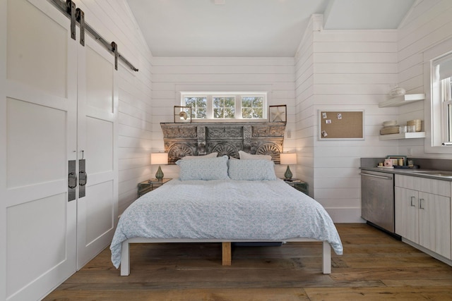 bedroom featuring dark wood-type flooring, lofted ceiling, wooden walls, and a barn door