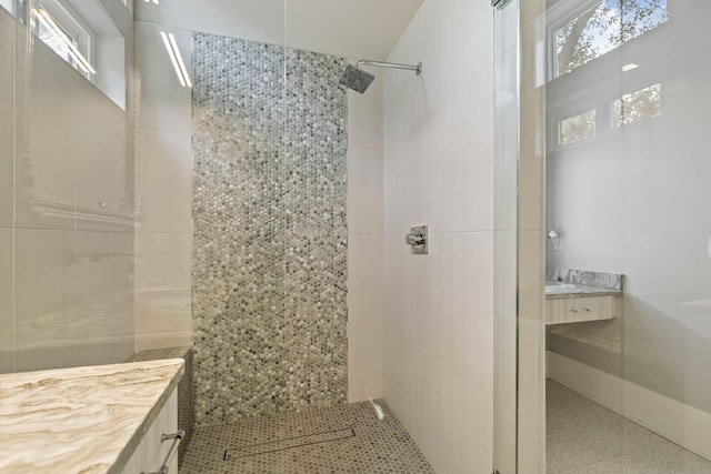 bathroom featuring a tile shower and vanity