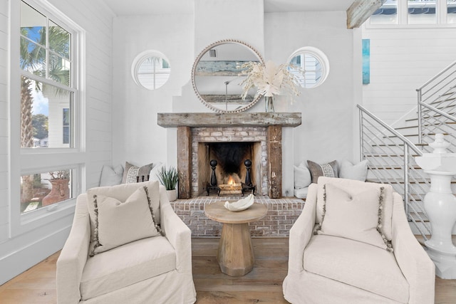 sitting room featuring stairway, plenty of natural light, and wood finished floors