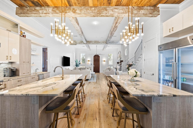 kitchen featuring pendant lighting, open floor plan, white cabinetry, and an inviting chandelier