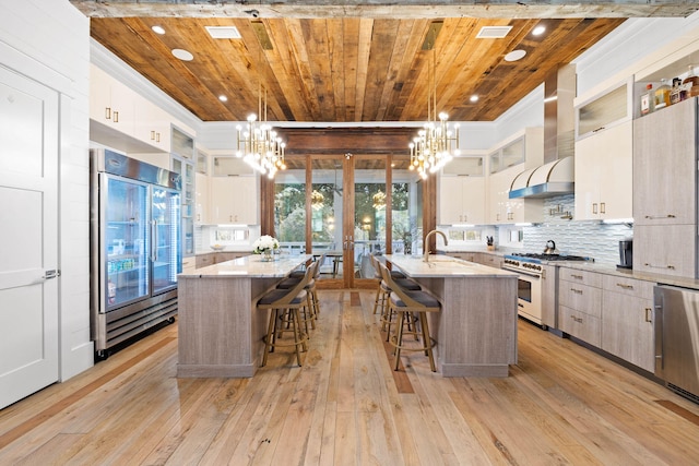 kitchen with a center island with sink, high quality appliances, and pendant lighting