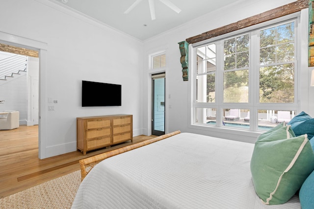 bedroom with ornamental molding, wood finished floors, a ceiling fan, and baseboards