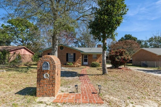 ranch-style house with brick siding, fence, and a front lawn