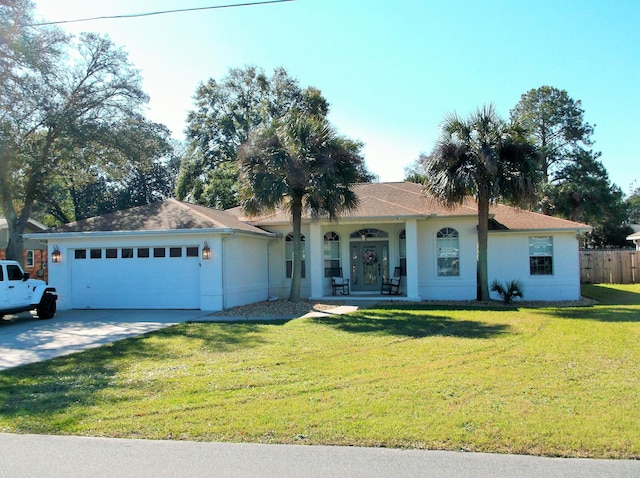 ranch-style home with an attached garage, covered porch, driveway, and a front yard