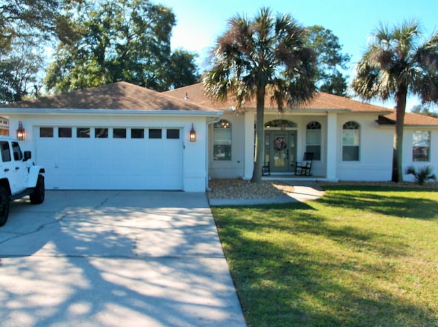 view of front of home featuring a garage, a front yard, concrete driveway, and covered porch