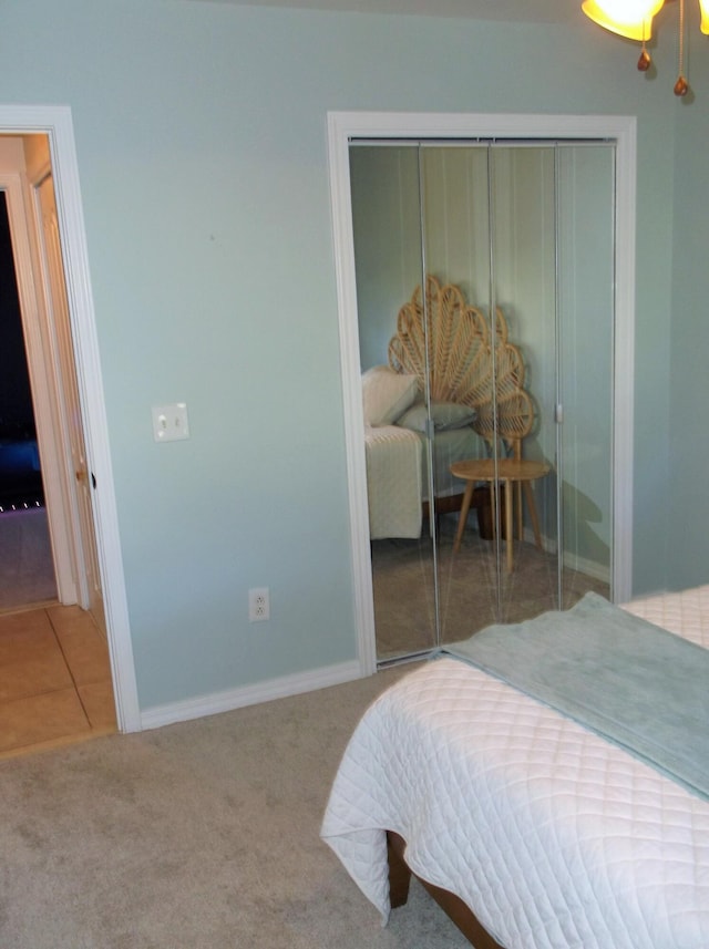 carpeted bedroom with tile patterned flooring, a closet, and baseboards