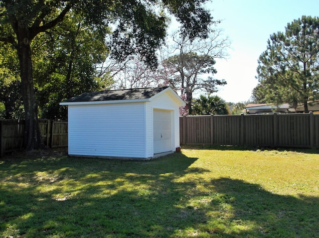 view of yard featuring a fenced backyard, a shed, and an outbuilding