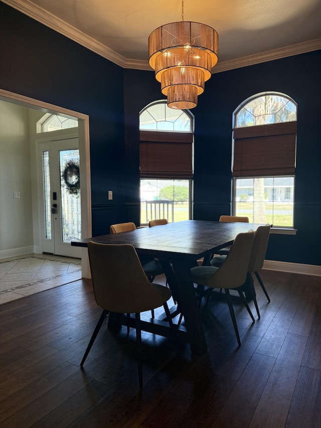 dining space with a notable chandelier, dark wood-style flooring, baseboards, and crown molding