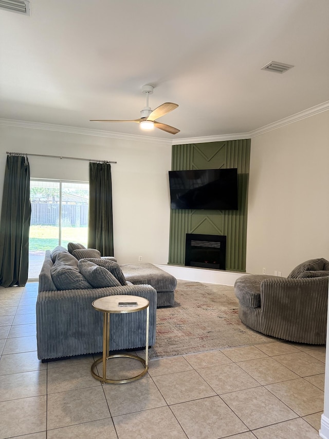 living area with a ceiling fan, light tile patterned flooring, visible vents, and crown molding