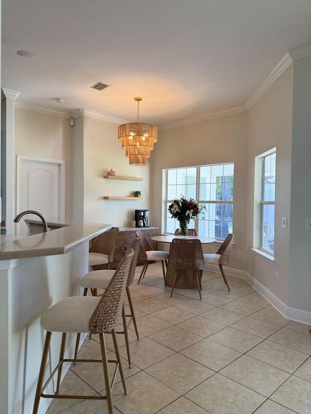 dining area featuring light tile patterned floors, visible vents, ornamental molding, and baseboards