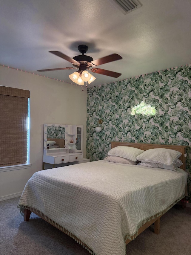 carpeted bedroom featuring baseboards, a ceiling fan, visible vents, and wallpapered walls