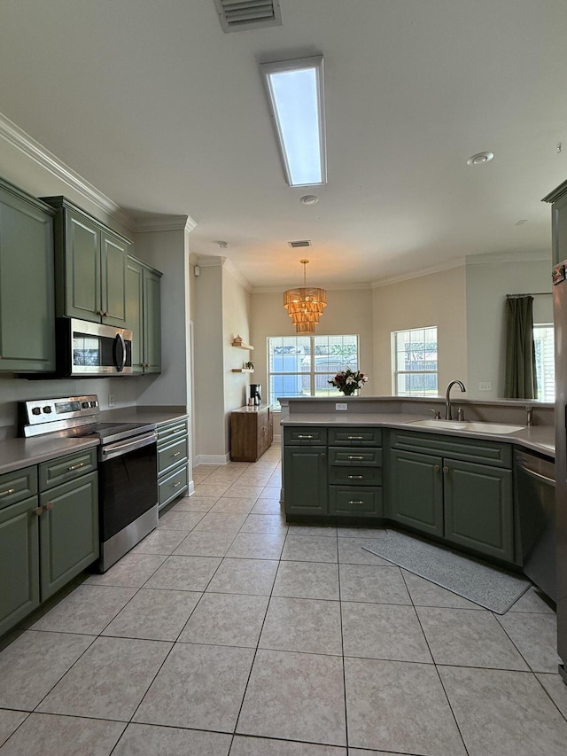 kitchen featuring visible vents, pendant lighting, stainless steel appliances, crown molding, and green cabinets