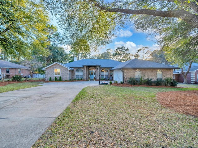 ranch-style home with concrete driveway, a front lawn, a chimney, and brick siding