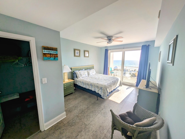 bedroom with a ceiling fan, access to outside, a walk in closet, and baseboards