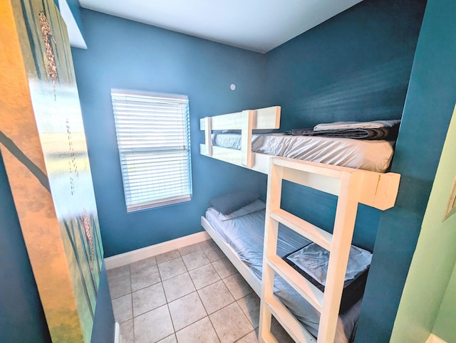 bedroom with light tile patterned flooring and baseboards