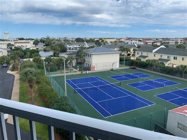 view of tennis court featuring fence and a residential view