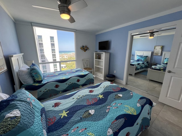 bedroom featuring a ceiling fan, crown molding, baseboards, and tile patterned floors