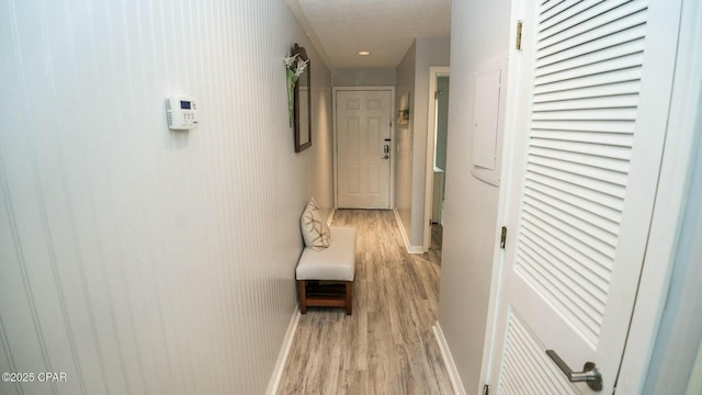 corridor with light wood finished floors and baseboards