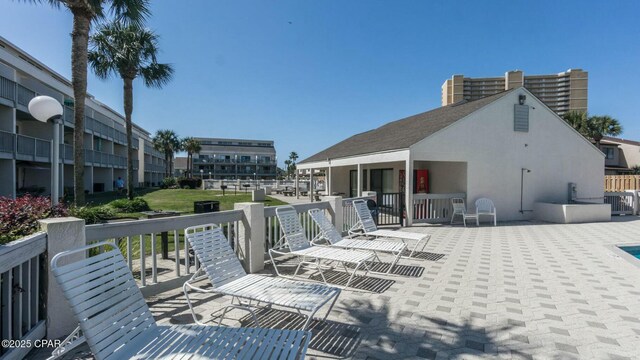 exterior space with a patio, central AC unit, and stucco siding