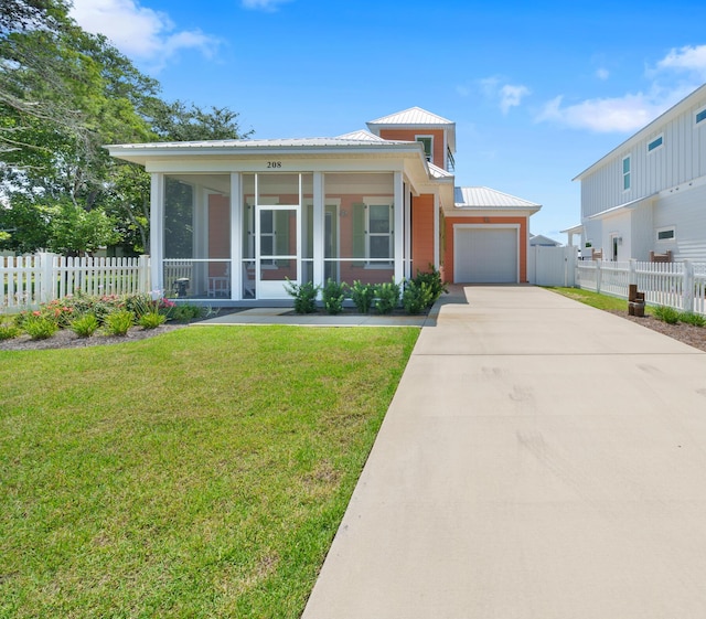 view of front of property with a garage, concrete driveway, a sunroom, metal roof, and a front lawn