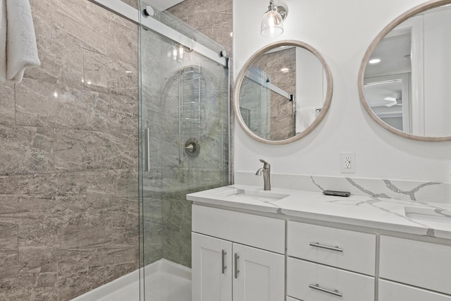 full bath with a stall shower, a sink, and double vanity