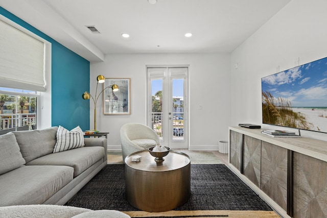 living area with recessed lighting, french doors, visible vents, and baseboards